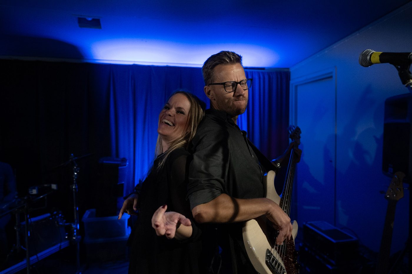 Sångerska och basist spelar rygg mot rygg på scen